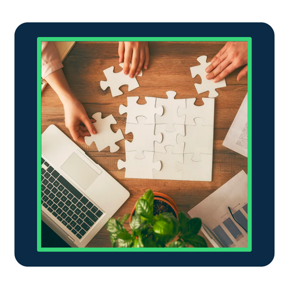 Paper puzzle pieces attached together on office desk with a laptop