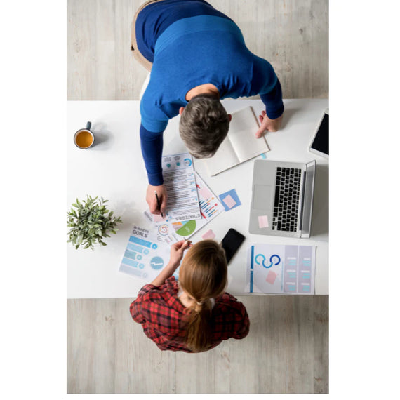 Bird eye view of two individuals reviewing marketing statistics
